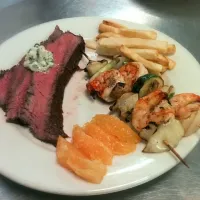 med rare roast steak with chive and garlic butter creme, homemade fries with salt and white pepper, orange slices, and grilled shrimp skewers|eleni rae mcclellanさん