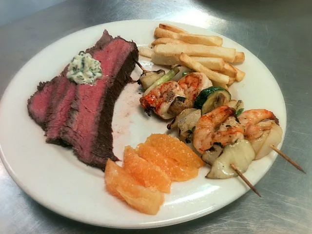 med rare roast steak with chive and garlic butter creme, homemade fries with salt and white pepper, orange slices, and grilled shrimp skewers|eleni rae mcclellanさん