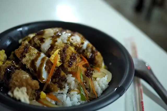 日本料理の屋台があった。カツ丼(カウペーンムートート)があったので試してみた。カツ閉じ丼だけど、上にトンカツソースが…。学生に値段を聞かれ、50バーツと答えると、高い!!と言われた。|msdsystemさん