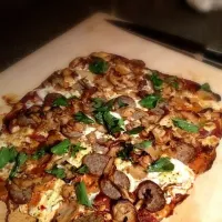 Pizza with Caw Caw Creek Italian sausage, red onion, sautéed pink oyster mushrooms with white wine and garlic, herbed goat cheese, and lemon basil.|michael anzelmoさん