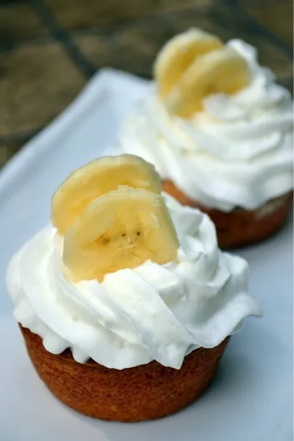 Yellow cupcakes with banana filling and whipped cream topping|liisさん