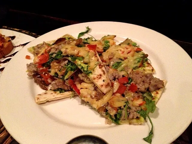 Italian Sausage Flatbread with wilted arugula, roasted red peppers, and smoke gouda cheese|valintinus domingoさん