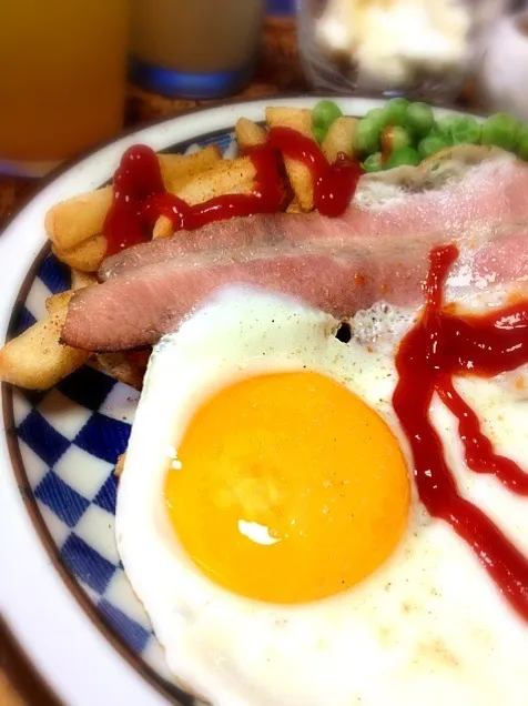 ワンパターンの休日朝ごはん／ベーコンエッグ、フレンチフライ、グリンピース、ソーセージ🍳|にょんにいさん