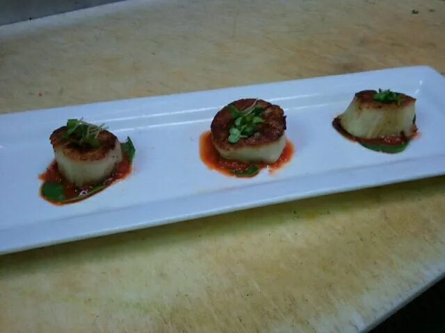 Seared scallops over roasted red pepper puree on a baby spinach leaf|Jacki Carterさん