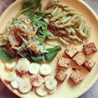 Snapdishの料理写真:seasoned tofu, organic wild pesto on whole grain penne, a cucumber carrot salad on a bed of fresh spinach, and sliced bananas sprinkled with cinnamon for desser|Gaby Cさん