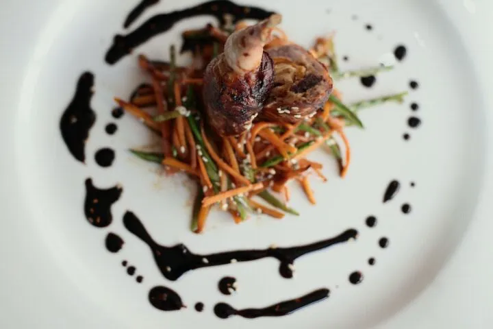 Quail stuffed with dried apricot and scallop, served with sesame vegetables and Indonesian soy|Adrian Buchananさん