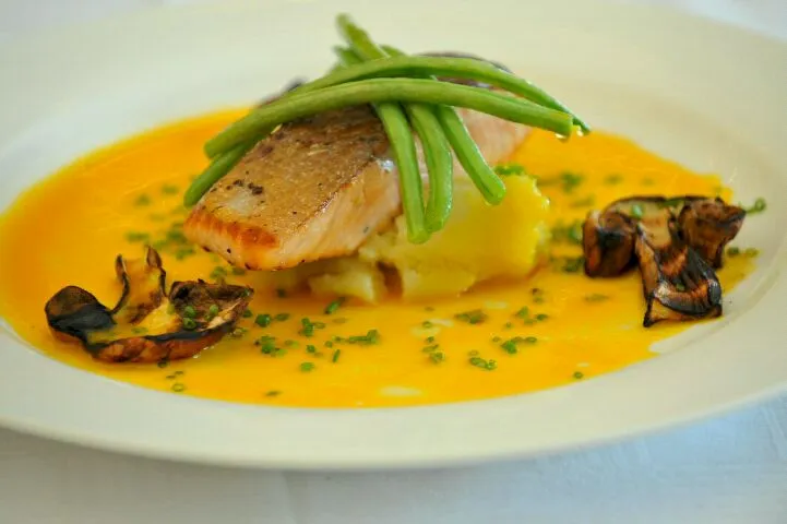 pan fried salmon steak over mashed potato with fine beans, grilled porcini and an emulsification of olive oil & orange.|Adrian Buchananさん