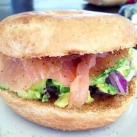 Bagel with mashed avocado, salmon and red union