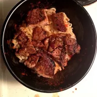 Ramen noodles topped with marinaded pan seared pork chops.  With a sprinkle of paprika.|josh avilesさん