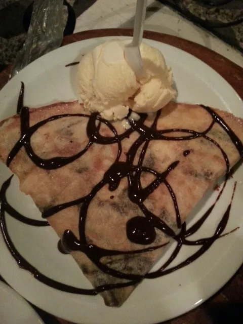 Crepe de banana com chocolate, queijo, cobertura de chocolate e castanha servido com sorvete de creme.|Andrezza Meloさん