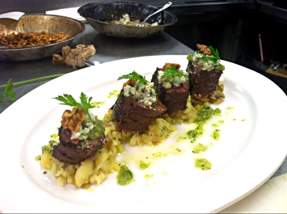 Strip steak over smashed potatoes topped with blue cheese and candied walnuts served with a chimircuri sauce|Andrew C Messinaさん