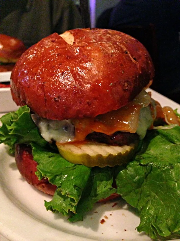 Snapdishの料理写真:Half ground beef/half ground bacon patty, grilled onions, beer-battered jalapeños, pickles, lettuce, and hot sauce on a bacon pretzel bun.|Chris Rothさん