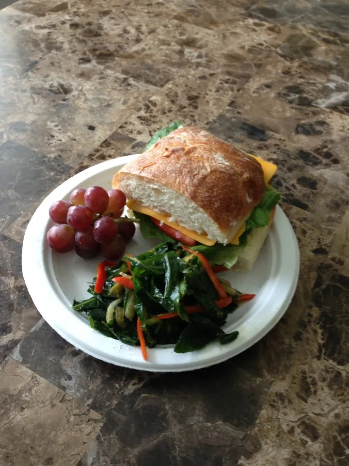 Paper plate lunch! Veggie and cheese sandwich on ciabatta with raw marinated collard greens.|erikka hartさん