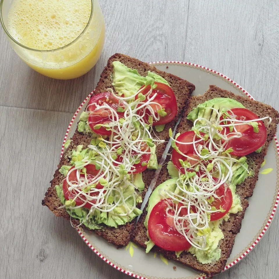 Snapdishの料理写真:Sprouted rye bread with mashed avocado, red chili flakes, tomato slices and radish sprouts|Rianneさん