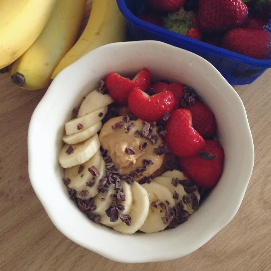 Oatmeal cooked with unsweetened almond milk, raw cacao and chia seeds, topped with banana slices, strawberries, homemade peanutbutter and cacao nibs|Rianneさん