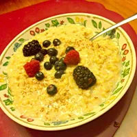 Oatmeal with flaxseed almond milk honey and berries on top|anikaさん