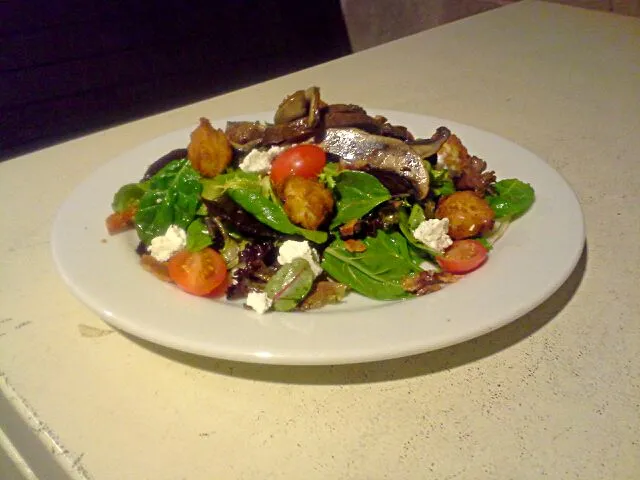 Grilled Portobello, bacon, goat cheese, cherry tomatoes, mixed greens with grilles tomato vinaigrette and 3 cheese polenta croutons|Austin Greenさん