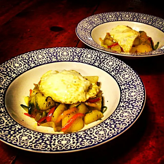 Potato, bell pepper, onion, and zucchini hash with a fried egg.|Austin Greenさん