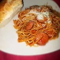 Spaghetti in tomato basil sauce with Polish kielbasa topped with fresh Parmesan cheese and garlic bread.|Natalia Lopez Alvizarさん