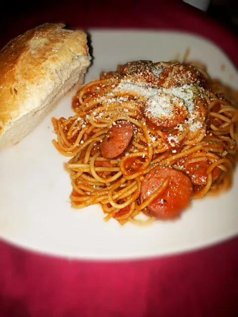 Spaghetti in tomato basil sauce with Polish kielbasa topped with fresh Parmesan cheese and garlic bread.|Natalia Lopez Alvizarさん