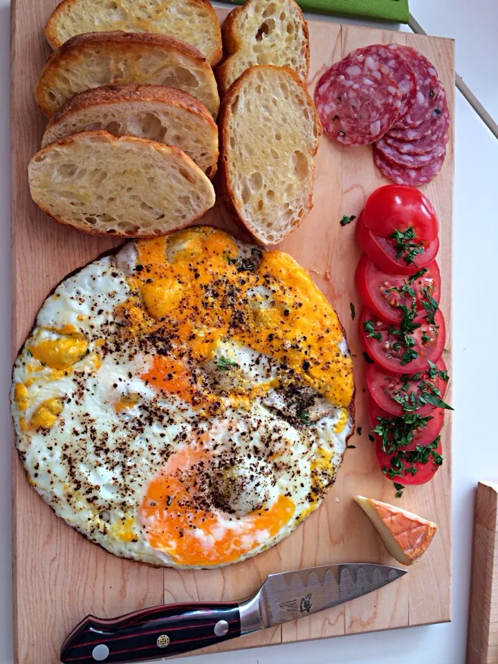 Farm fresh eggs over diced serrano, saucisse au sec, Roma tomato and cilantro, affedelice au chablis cheese, pan toasted belgian style  baguette|john rudolphさん