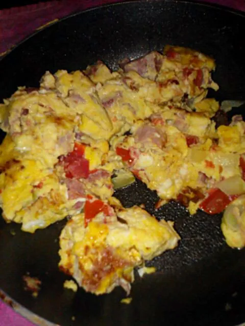 Scrambled eggs with ham, tomato, onion, and feta.|Polly Gelfusoさん