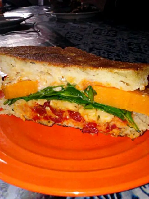 Ciabatta Panini with sweet potato, red pepper spread, homemade pickled elegant, spinach, mayo, sundried tomatoes, and Daves ghost pepper hot sauce.|Polly Gelfusoさん