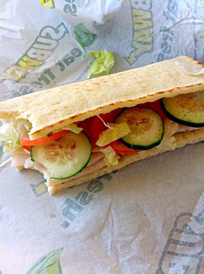 Snapdishの料理写真:subway flatbread turkey with provolone tomatoes cucumbers an lettuce with salt an pepper|Whitney Kinnisonさん