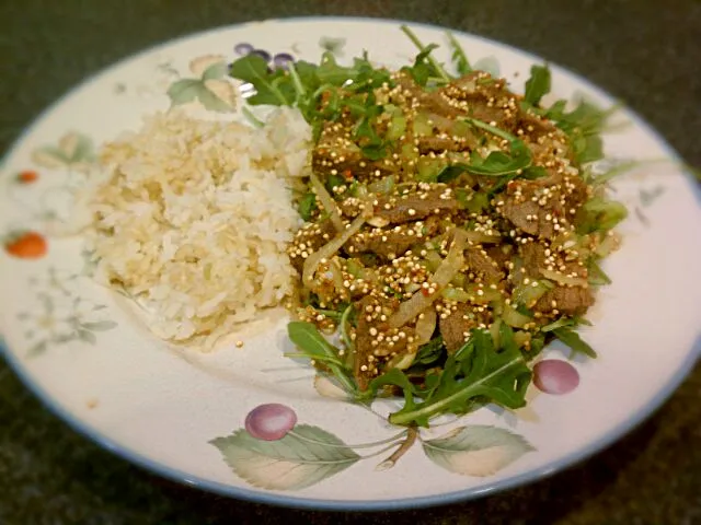 Thai beef salad on a bed of arugula with rice.|Jiraphon Gさん