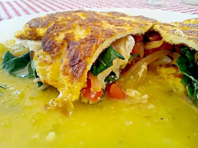 omelette filmes with goat chesse spinach onion and red bell pepper served over a mirror of green tomatillo with mezcal|miguel alvarezさん