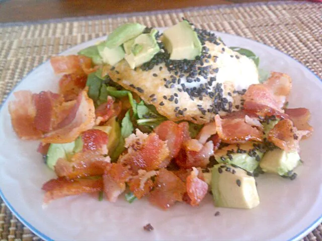 Cheddar cheese with biscuit topped with egg, spinach, avocado surrounded with bacon sprinkled with black sesame seeds.|Jiraphon Gさん