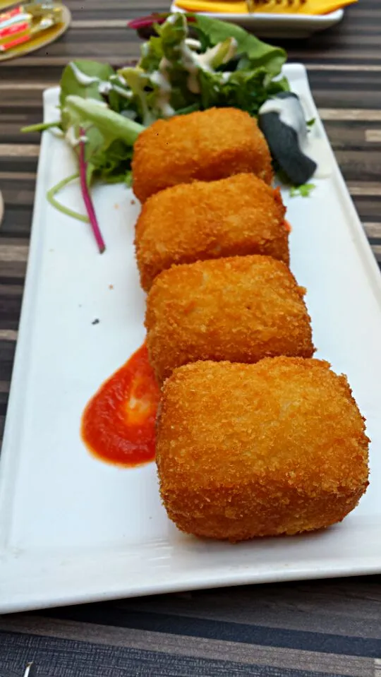 Parmesan cheese croquettes served on tomato coulis|genさん