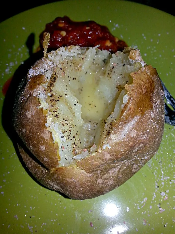 warm buttered baked potato with salt and pepper and chili paste.|Polly Gelfusoさん