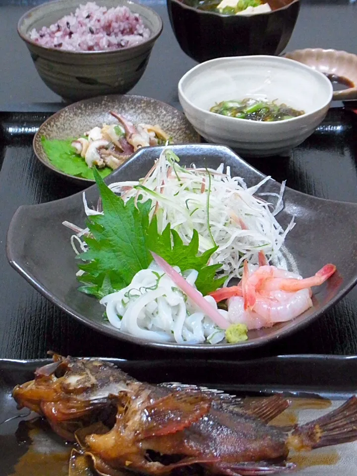 今晩は、ガシラ煮付け（カサゴ）甲烏賊の刺身、甘海老、ゲソの味噌炒め、もずく酢、ワカメと豆腐の味噌汁、黒豆ご飯

今日はカサゴと甲烏賊とが一盛りで売られていて、えい！と購入。
見た目の悪い魚ほど味がいいの代表のカサゴ。磯のカサゴは口ばかり、と食べられる部分は少ないけれど、美味しい魚です。
甲烏賊は博多作りにしようとしたも|akazawa3さん