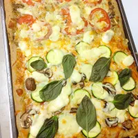 My split pan pizza. One side is topped with tomato sauce, zucchini, mushrooms, garlic. The other side is pesto sauce, tomatoes and garlic. Both sides have mozza|Annie Barrowsさん