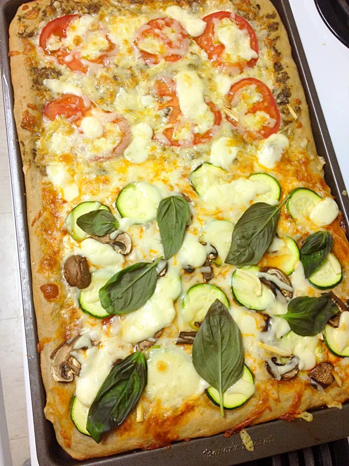 My split pan pizza. One side is topped with tomato sauce, zucchini, mushrooms, garlic. The other side is pesto sauce, tomatoes and garlic. Both sides have mozza|Annie Barrowsさん