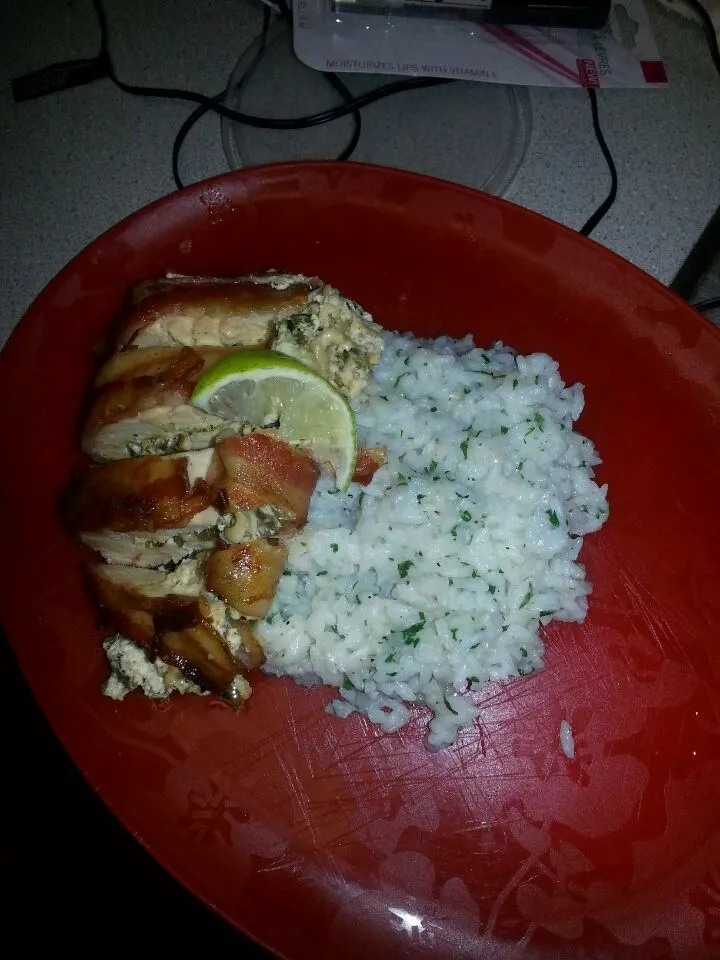 bacon wrapped chicken stuffed with pablanos caramelized onions roasted garlic and goat ch served with a cilantro lime rice .|Monique Whiteさん