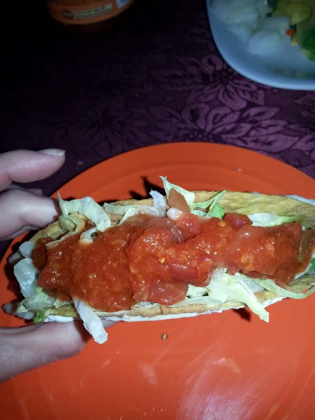 re fried been taco with tomato, onion, sour cream, avocado, lettuce,  And hot sauce.|Polly Gelfusoさん