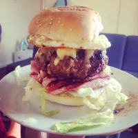 Burger with cheese filling served with egg bacon and iceberg|Charlotte Daviesさん