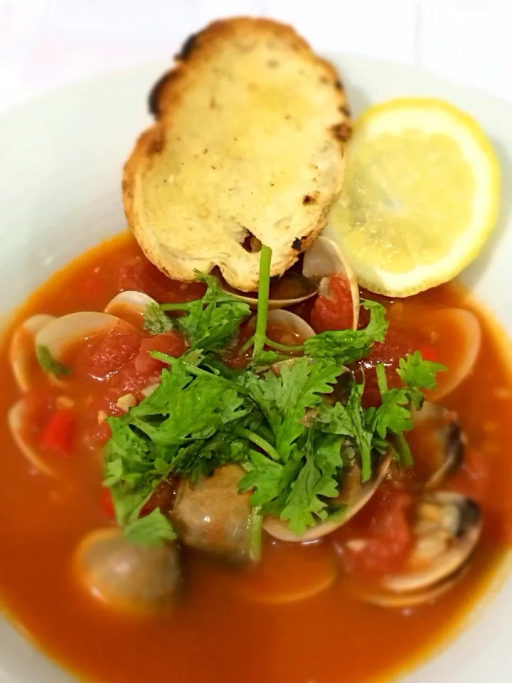 Snapdishの料理写真:Clams in tomato broth served with pan-fried garlic baguette|Elaine Gohさん