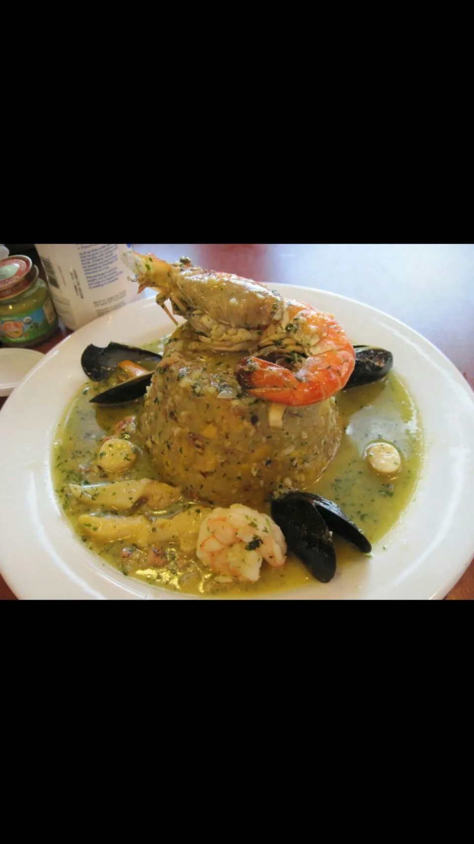 Puertorican style mashed fried green plantains with bits of pork skins. In a seafood broth shrimp and mussels.  The name of the dish is Mofongo in Spanish.|Frank Ortizさん