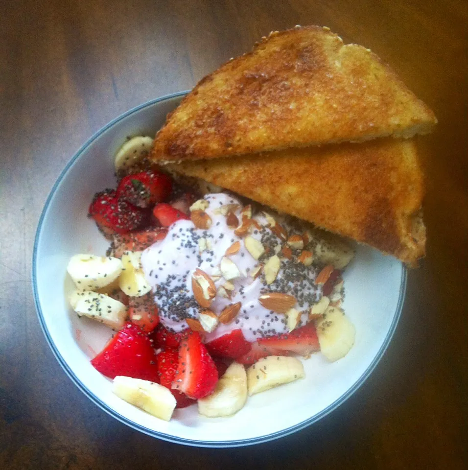 Yogurt bowl: strawberries & banana with almonds, chia seeds and strawberry Greek yogurt. 2 multigrain toasts with earth balance butter.|victoria valerioさん