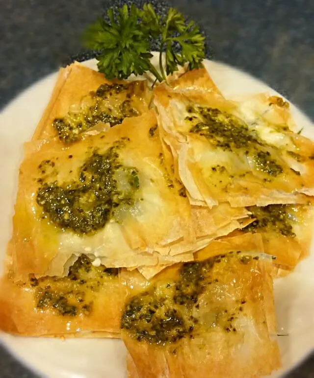 phyllo dough sandwiched with feta cheese and parsley topped with pesto|Jiraphon Gさん