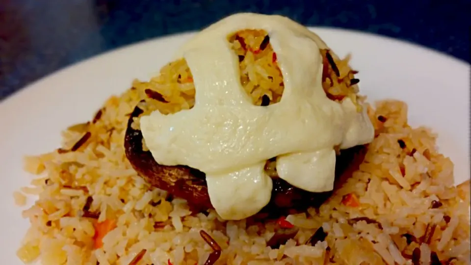 stuffed portabella mushroom with wild rice topped with melted queso blanco on a bed of wild rice|Jiraphon Gさん