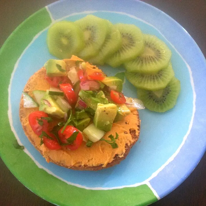 1/2 ww onion bagel with hummus, baby tomatoes, cucumber, avocado and cilantro with side of kiwi|victoria valerioさん