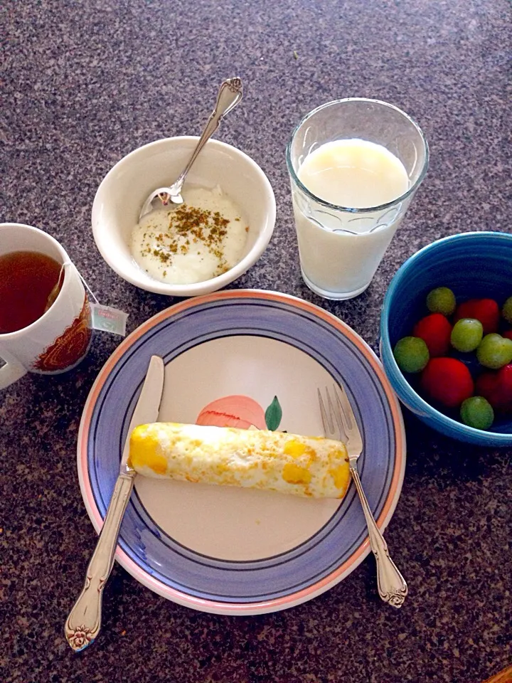 Eggs and cheese roll, green tea, milk, strawberries and grapes, and yogurt and thyme for breakfast|nadia issaさん