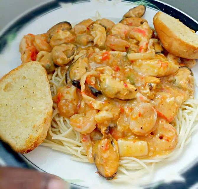 Creamy seafood butter sauce made with calamari mussels shrimp and crab over angel hair pasta with garlic roll and Moscato wine #goodeats #myrecipe#homemade#home|christl babcockさん