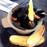 Snapdishの料理写真:Mussels in white broth served with garlic bread|Karen Yongさん