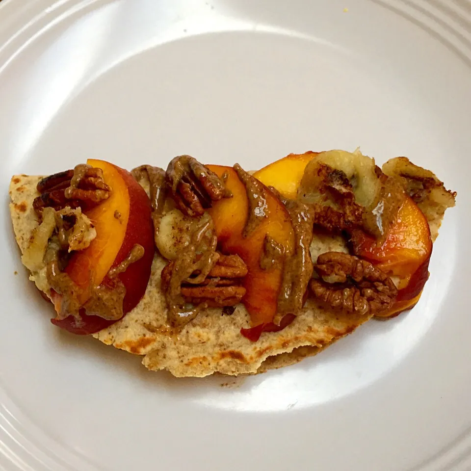 Whole wheat tortilla with almond butter and maple cinnamon glazed peaches, bananas & pecans and almond butter drizzled on top|victoria valerioさん