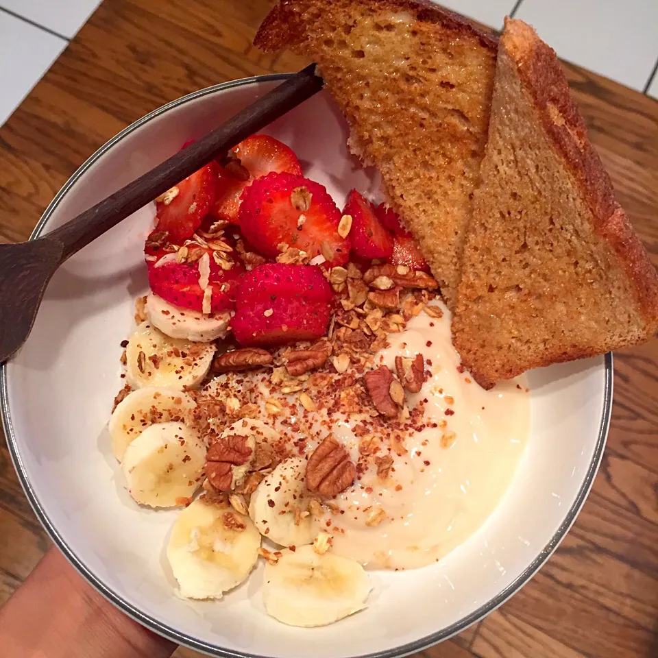 Soy peach yogurt with banana, strawberry, homemade granola and pecans. Side of whole wheat toast with earth balance butter|victoria valerioさん